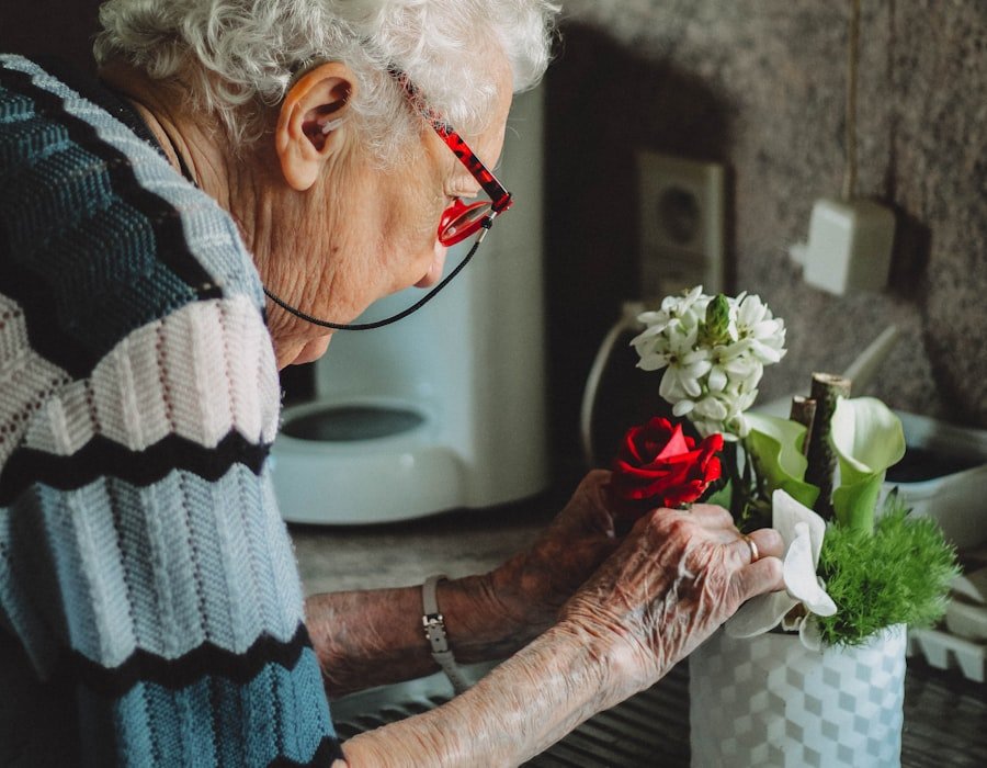 An elderly woman arranging flowers in a quiet, familiar room