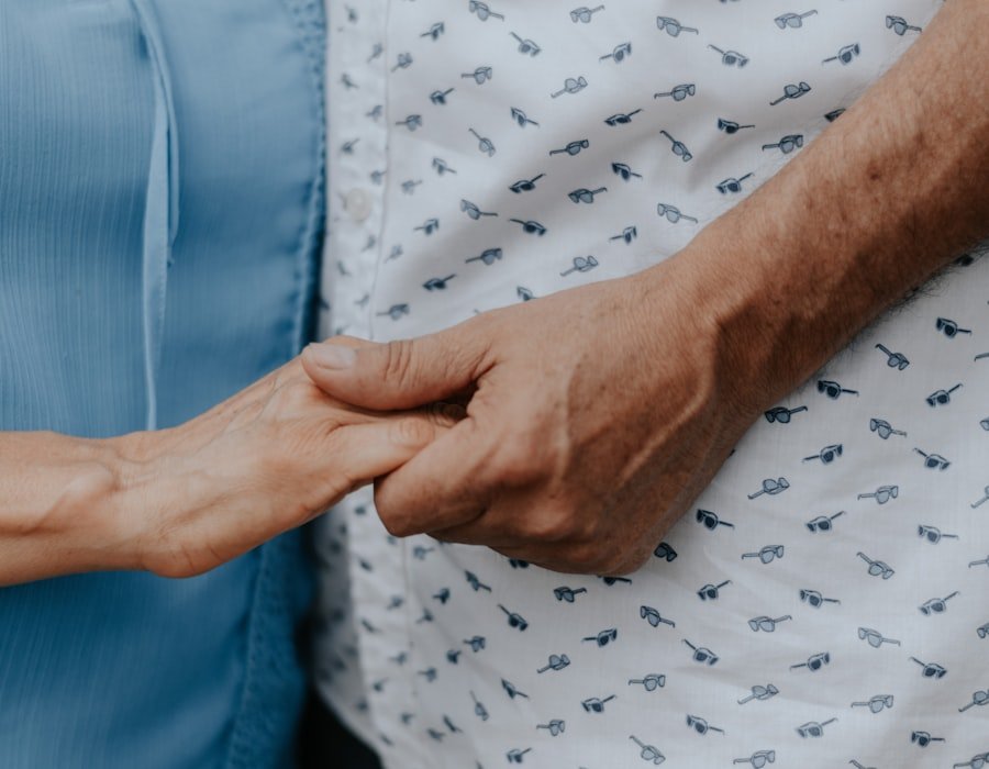Two people holding hands gently in a moment of comfort