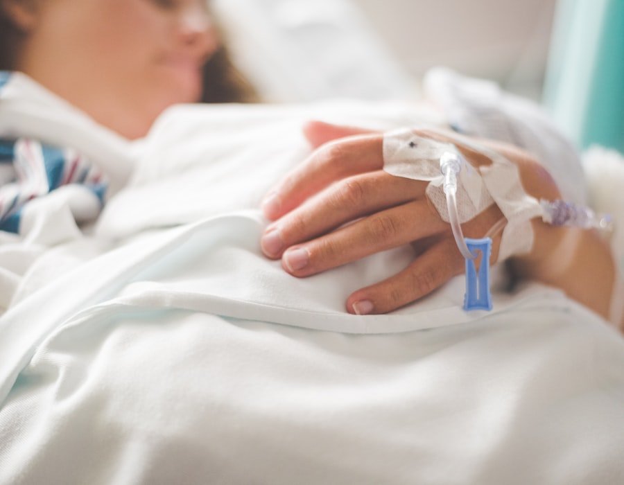 A patient's hand resting on a hospital bed during a stay