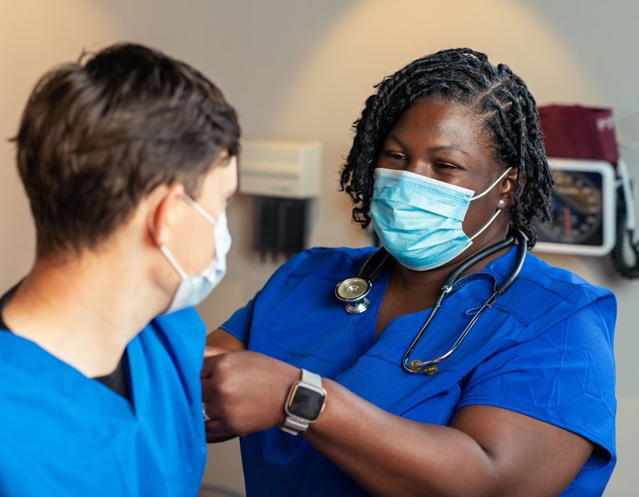 Two healthcare professionals in scrubs conferring in a clinical setting