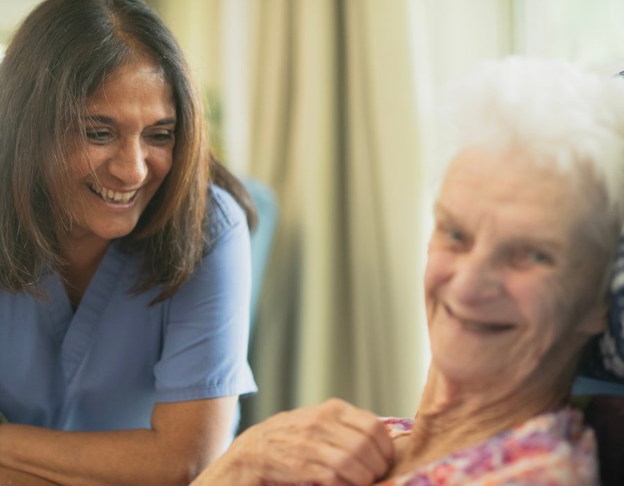 A nurse smiling in conversation with an elderly patient at home