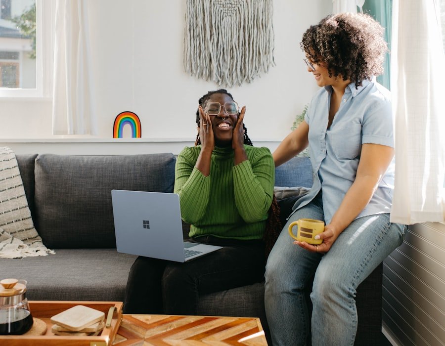 A woman on a video call at home while a care worker sits nearby